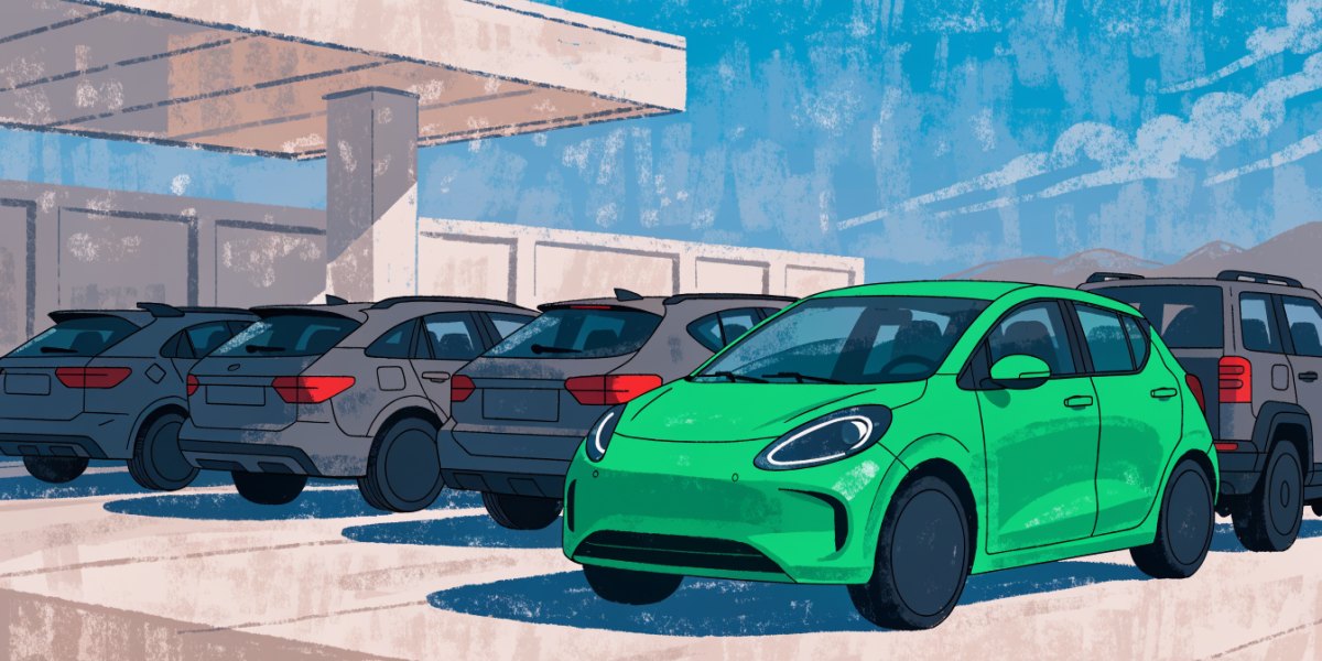 A green electric hatchback at the front of a row of used SUVs on a dealer forecourt